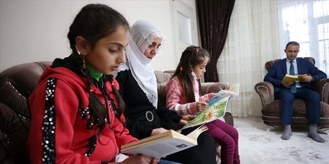 Öğretmenler evleri ziyaret edip öğrenci ve velilerle kitap okuyor