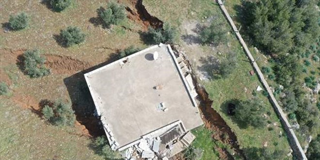 Deprem bölgesindeki bir ev, arazide oluşan yarığa gömüldü