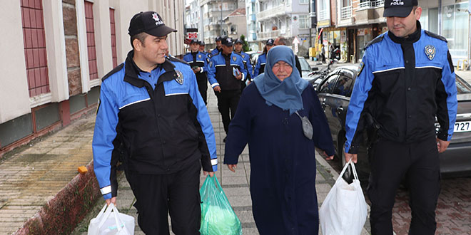 Polis pazarda yorulan yaşlı kadının çantalarını evine götürdü
