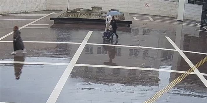 Osmaniye'de engelli vatandaşa şemsiye tutarak ıslanmasını önleyen polise başarı belgesi