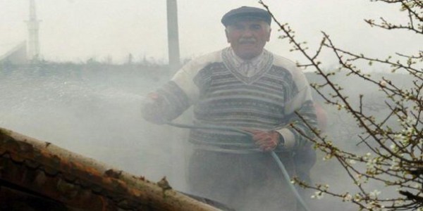 Yanan evini hortumla su sıkarak söndürmeye çalıştı