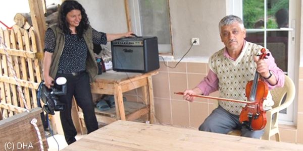 Evinde müzik estrümanı yapıp, dizinde keman çalıyor