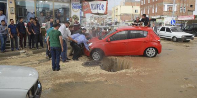 Çukura düşen otomobili vatandaşlar çıkardı