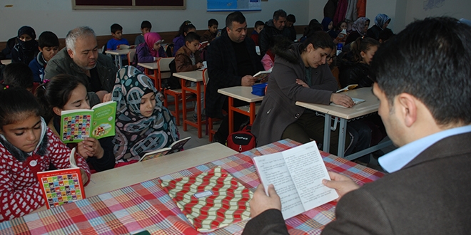 Öğrenci, öğretmen ve veli birlikte kitap okuyor