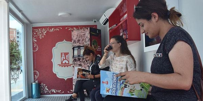 Otobüs beklerken kitap okuyup kahve içiyorlar