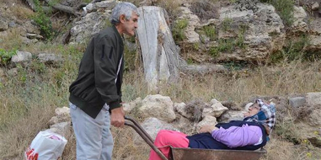 Felçli eşini el arabasında hastaneye götürüyor