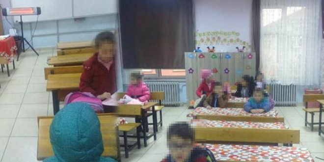 Kış günü sınıfta mont ve bere ile ders işliyorlar