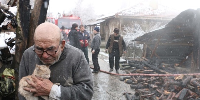 Evinin yanışını, kedisine sarılıp izledi
