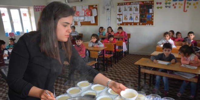 Öğrencilerine odun sobasında puding hazırlıyor
