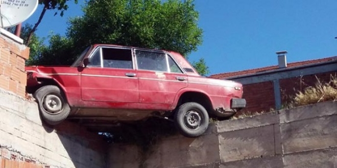 Kaza yapan araç havada asılı kaldı