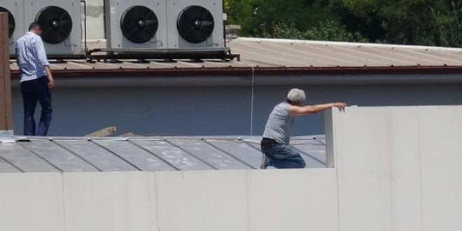 Parasını alamayan taşeron firma sahibi çatıya çıktı