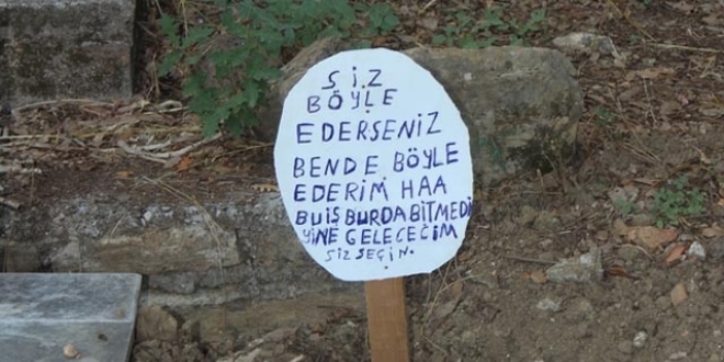 Mezar taşını söküp 'Bu iş bitmedi' yazılı tabela diktiler