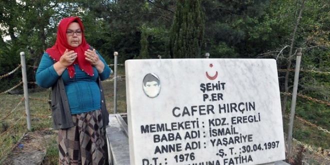 Eşinin bulunması için şehit oğlunun mezarında dua ediyor