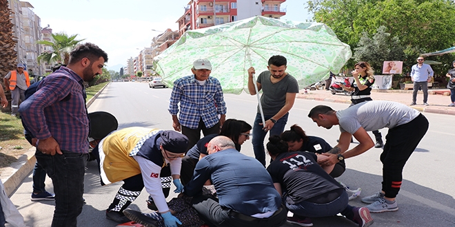 Yaralı kadını sıcaktan şemsiyeyle korudular