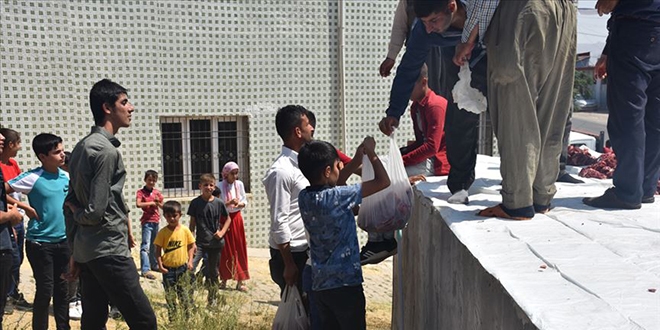 Kurban etini köy meydanında bölüşüyorlar
