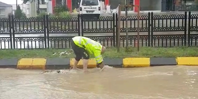 Trafik polisi ayakkabılarını çıkardı, mazgalları temizledi