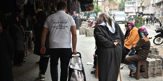 Belediye ekipleri, yaşlıların torbalarını taşıyor