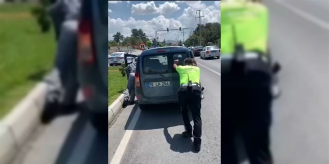 Trafik polisi, yolda kalan aracı iterek sürücüye yardım etti