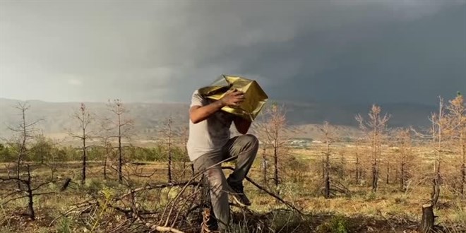 Başındaki teneke kutuyu çalarak orman yangınlarına dikkati çekti