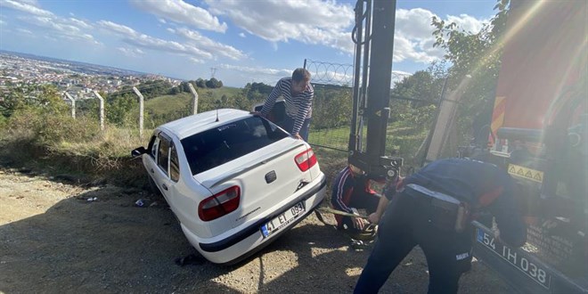 Devrilme riski olan otomobilini kurtarmak için üzerine çıktı