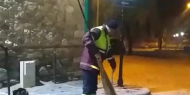 Hem çevreyi temizliyor hem de sokak kedisine masaj yapıyor