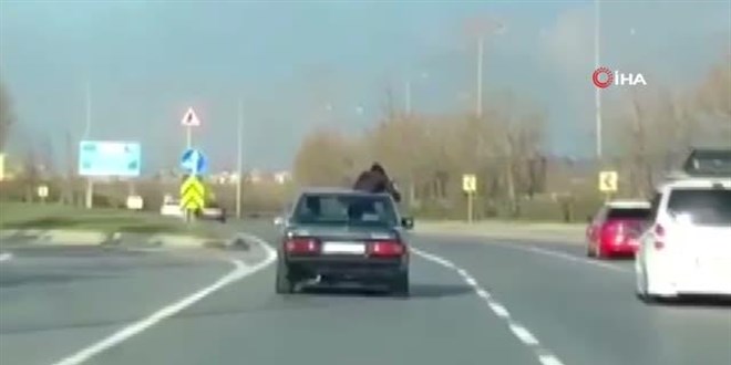 Video çekmek için trafikte arabadan sarkan şahıs yürekleri ağza getirdi