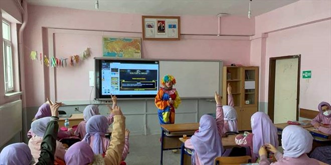 Öğrencilere okulu sevdirmek için derse palyaço kıyafetiyle giriyor