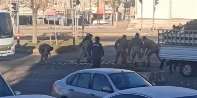 Yola saçılan elmaları, askerler elleriyle topladı