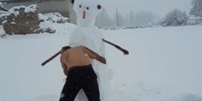 Dondurucu soğukta soyundu, kardan adamla güreşti