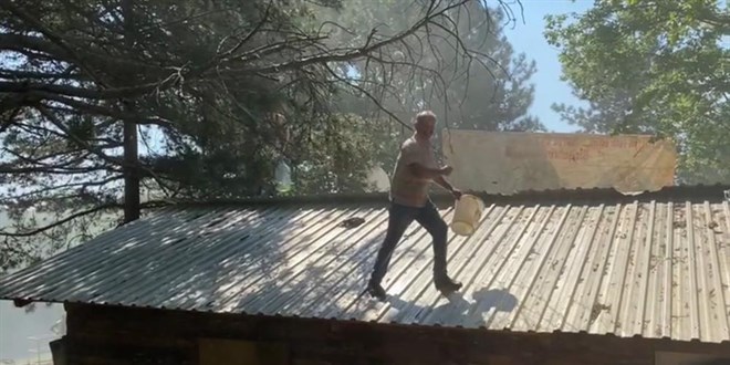 İnekleriyle belediyeyi basmıştı...Şimdi de benzin bidonuyla çatıya çıktı