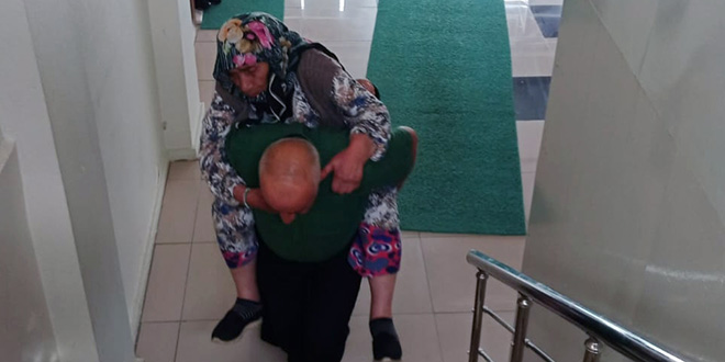 Nüfus müdürlüğü memuru, yaşlı kadını müdürlük ofisine sırtında taşıdı