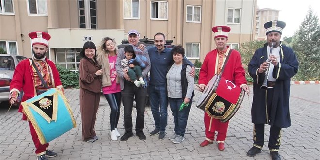 Çinli gelinini, oğlunu ve ilk kez gördüğü torununu mehter marşı ile karşıladı