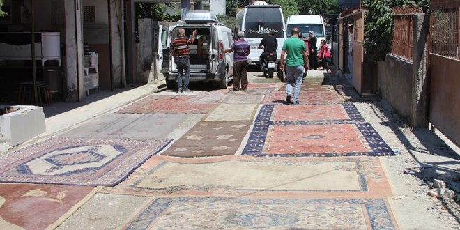 Asfaltlanmayan soka��n tozundan rahats�z olan mahalleli yola hal� serdi