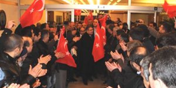 Eski bakana bayraklı posterli karşılama