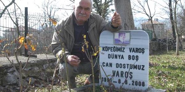 Köpeğinin mezarı başında dua okuyor