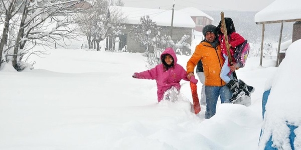 Yol kapanınca öğretmen, öğrencilerini kucağında taşıyor