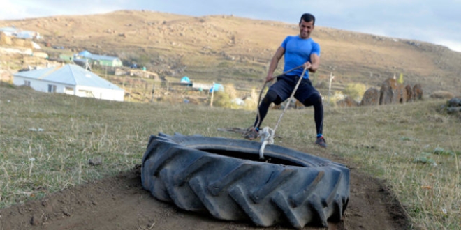 Beden eğitimi öğretmeni taş, odun ile crossfit sporu yapıyor