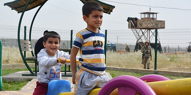 Sınırda asker görev yapıyor, çocuklar parkta oynuyor