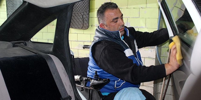Akülü sandalyesiyle oto yıkamacılık yapıyor