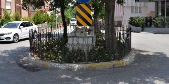 Yol ortasında kalan mezarın başında dua ediyorlar