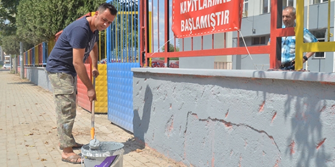 Okul müdürü elinde fırçayla okulu boyuyor