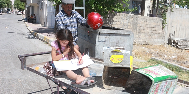 Babasının çöpten topladığı kitapları okuyor