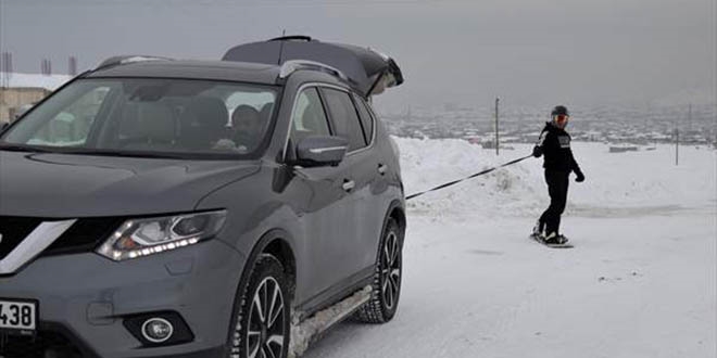 Van'ın karlı sokaklarında snowboard yaptı