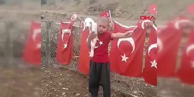 Kucağında kuzusu, elinde bayrağıyla fenomen oldu