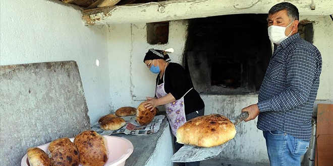 Muhtar dışarı çıkamayanlar için fırında ekmek pişiriyor