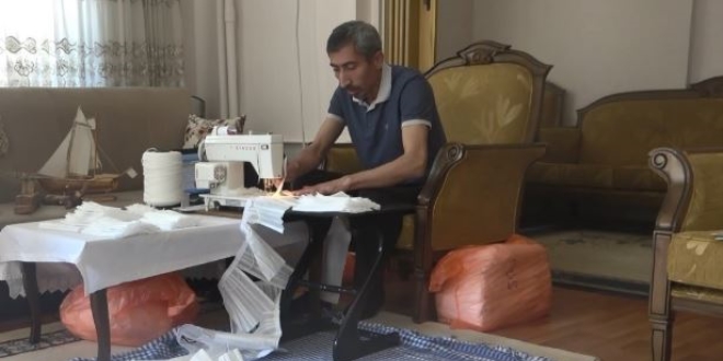 Memur, sağlıkçılar için evinde maske üretiyor