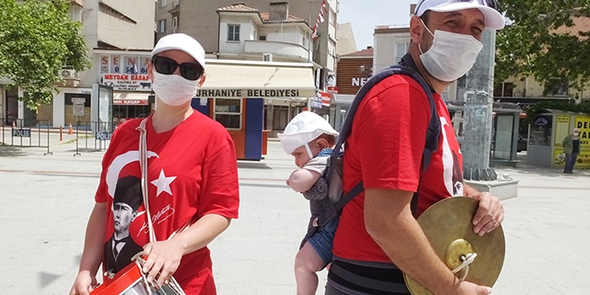 Öğretmen sırtında çocuğu ile halk bandosunda görev aldı