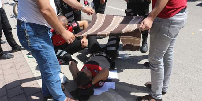 Trafik kazasında yaralanan polisleri tişörtle güneşten korudular