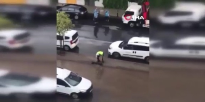 Trafik polisi caddeyi basan suyun tahliyesi için seferber oldu