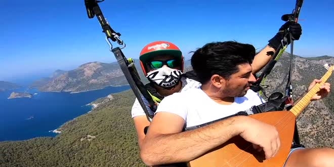 Yamaç paraşütüyle atlayan polis, gökyüzünde saz çalıp Neşet Ertaş türküsü söyledi